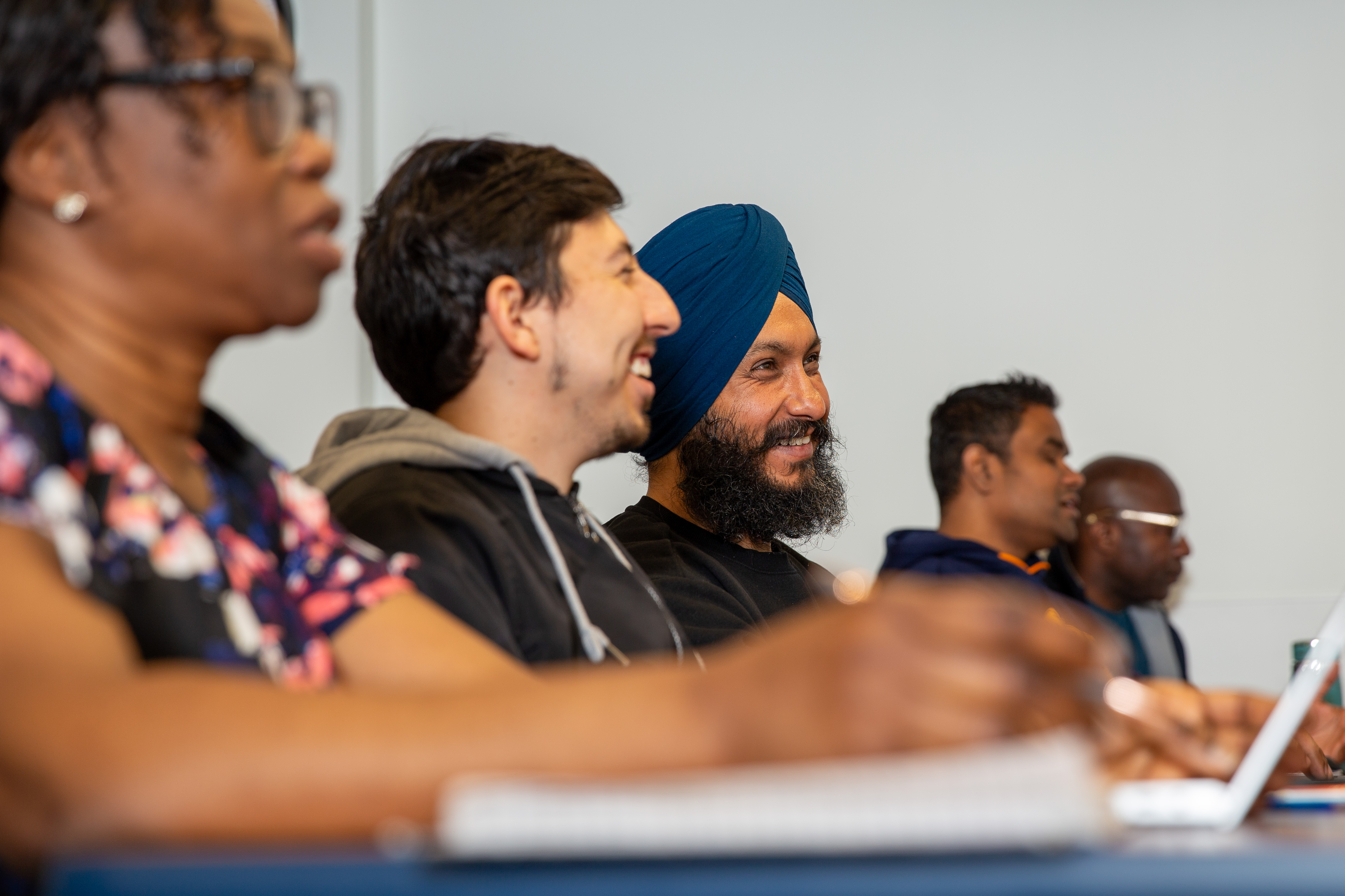 A group of diverse PACE students attentively engaged in a classroom session.