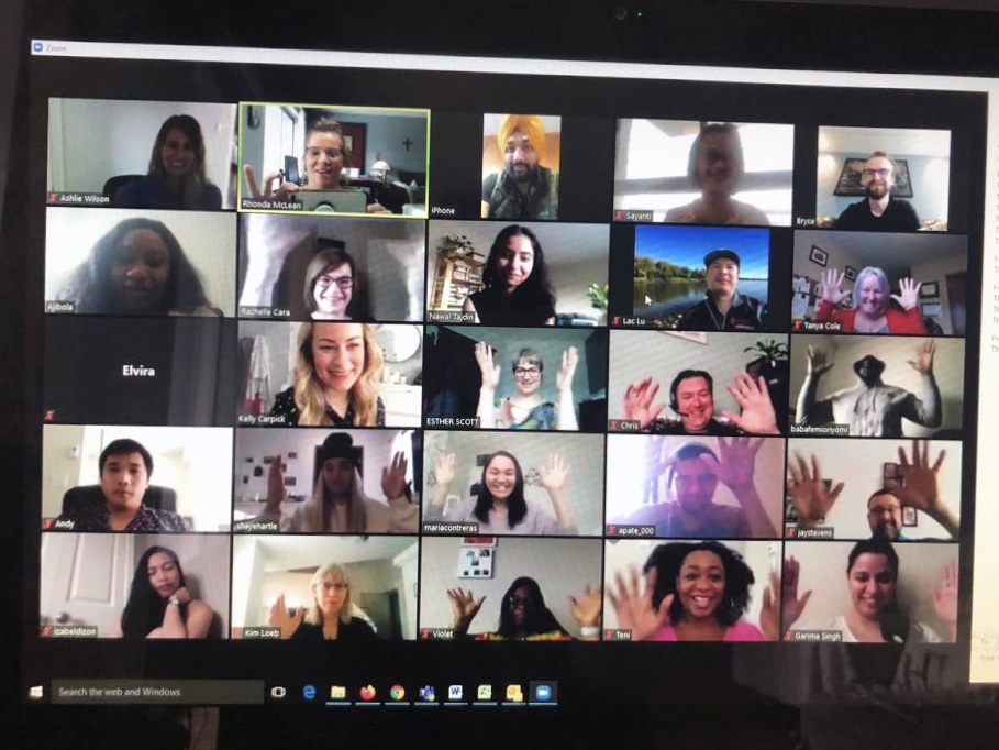 A screen shows 25 participants on a Zoom call, many with their hands in the air in celebration